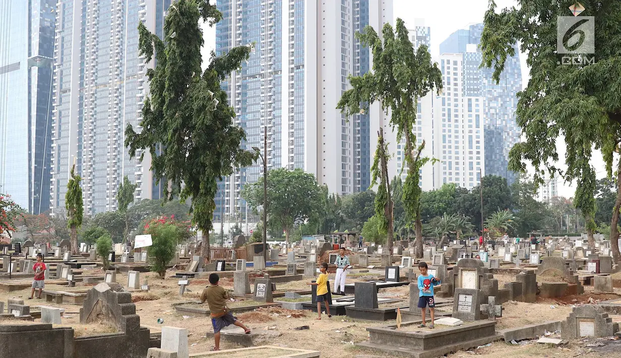 Anak-anak bermain layang-layang di TPU Menteng Pulo, Jakarta, Kamis (18/10). Padatnya pemukiman penduduk serta gedung bertingkat di kawasan tersebut menyebabkan anak-anak terpaksa bermain di tempat yang tidak semestinya. (Liputan6.com/Immanuel Antonius)