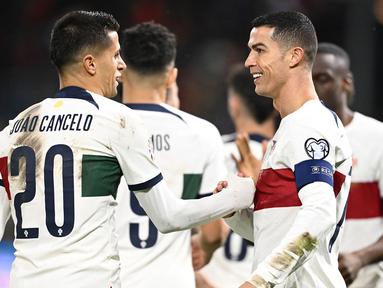 Setelah dipastikan lolos ke Putaran Final Euro 2024, Timnas Portugal melakukan beberapa perubahan susunan pemain saat meladeni tuan rumah Liechtenstein pada laga lanjutan Grup J Kualifikasi Euro 2024 di Rheinpark Stadium, Vaduz, Jumat (17/11/2023) dini hari WIB. Hasilnya, Cristiano Ronaldo dkk masih terlalu perkasa dan menyudahi laga dengan keunggulan 2-0. Kedua gol tim asuhan Roberto Martinez masing-masing dicetak oleh Cristiano Ronaldo pada menit ke-47 dan Joao Cancelo sepuluh menit kemudian. Bagi CR-7, tambahan satu gol membuatnya telah mengoleksi total 128 gol bagi Timnas Portugal sepanjang kariernya. (AFP/Sebastien Bozon)