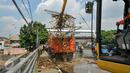 Alat berat memindahkan sampah ke truk pengangkut sampah di jembatan Kampung Melayu, Jakarta, Minggu (3/4/2016). Akibat luapan Ciliwung, tumpukan sampah menyangkut di jembatan Kampung Melayu. (Liputan6.com/Yoppy Renato)
