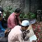 Para kerabat berdoa disamping makam alm Guntoro di Lenteng Agung, Jakarta, Kamis (16/2). Diduga terkena serangan jantung , Guntoro, wartawan foto, Koran Jakarta meninggal dunia saat meliput banjir di daerah Pejaten Timur. (Liputan6.com/Faizal Fanani)