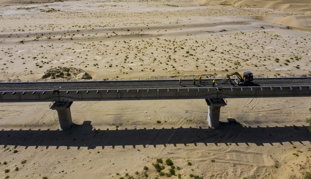 Para pekerja bekerja di lokasi konstruksi jaringan kereta Hotan-Ruoqiang di Daerah Otonom Uighur Xinjiang, China, 25 September 2020. Dengan total panjang sekitar 825 kilometer, jaringan kereta itu merupakan bagian penting dari loop kereta di Lembah Tarim. (Xinhua/Hu Huhu)