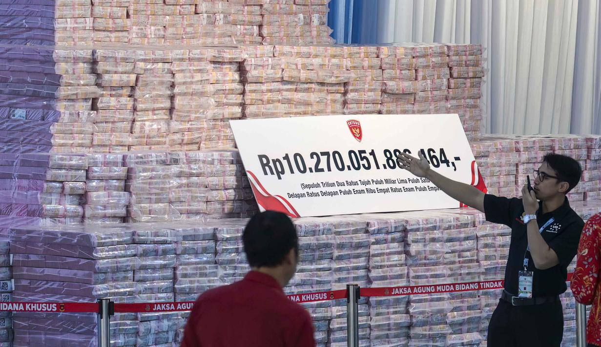 Selain uang, diserahkan juga penguasaan kembali lahan seluas 2,3 juta hektare kepada negara. Tampak dalam foto, para pejabat menyiapkan tumpukan duit kertas rupiah senilai sekitar 586,8 juta USD, nan disita dari beragam kasus korupsi dan denda lingkungan, sebelum upacara penyerahan dari Kejaksaan Agung kepada pemerintah Indonesia di gedung Kejaksaan Agung di Jakarta pada Rabu 13 Mei 2026. (BAY ISMOYO/AFP)