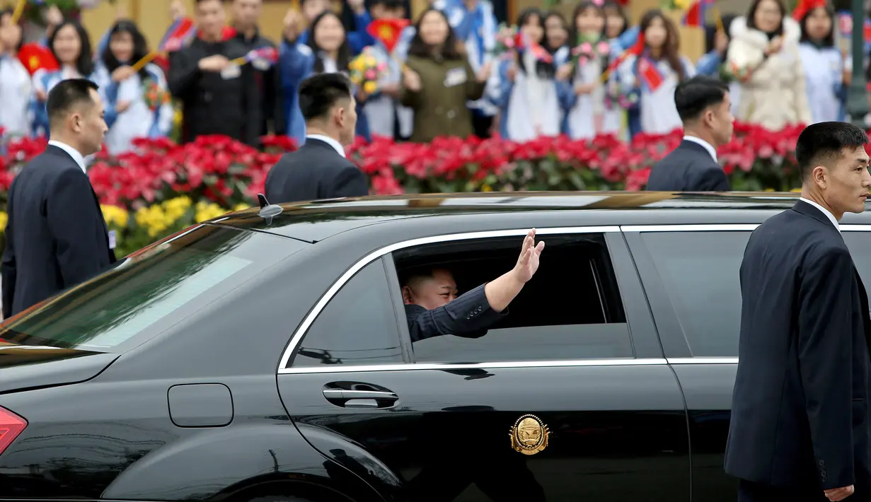 Pemimpin Korea Utara, Kim Jong-un melambaikan tangan dari dalam mobil setibanya di Stasiun Dong Dang, Lang Son, Vietnam, Selasa (26/2). Para pengawal mengiringi mobil Mercedez Bens yang membawa Kim menuju Hanoi sejauh sekitar 170 km. (AP/Minh Hoang)