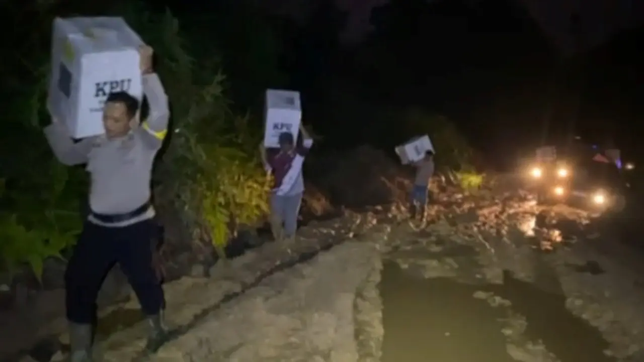 Polisi di Rokan Hulu dibantu warga menggendong logistik Pemilu 2024 agar sampai ke desa.