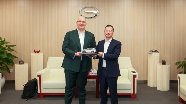 Philipp Kandal, Chief Product Oﬃcer Grab, menerima miniatur model kendaraan dari Xia Xianqing, Presiden GAC Group