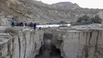 Warga Israel menyaksikan banjir bandang terjadi menyusul hujan lebat di gurun Negev di sebelah timur kota Dimona Israel pada 26 Desember 2022. Hujan lebat mengguyur Israel pada hari Senin (26/12) membanjiri jalan-jalan kota, memicu banjir bandang di dasar sungai gurun yang kering dan membasahi daerah pedesaan karena suhu turun ke level terendah musim ini. (AFP/Menahem Kahana)