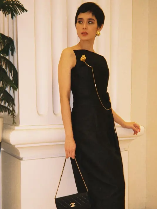 Ia juga mengenakan dress hitam sleeveless dari desainer Ari Saputra dipadukan bros rantai panjang warna emas serasi dengan anting-antingnya. Dipadukan tas Chanel hitam serta stiletto heels coklat. [@renata711]