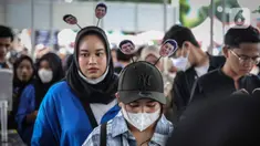 Seorang wanita mengenakan aksesoris foto tulus mengantre untuk menonton Konser Tulus yang bertajuk “Tulus Tur Manusia 2023" di Jakarta, Jumat (3/3/2023). Setelah melewati 10 kota dengan Medan sebagai kota pertama “Tulus Tur Manusia 2023” yang diadakan 1 Februari 2023 lalu, Jakarta menjadi penutup rangkaian manis ini dengan konser yang diadakan pada 3 Maret 2023 di JIEXPO Kemayoran Jakarta. (Liputan6.com/Faizal Fanani)