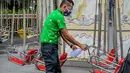 Seorang staf yang mengenakan masker mendisinfeksi wahana di taman hiburan Enchanted Kingdom di Provinsi Laguna, Filipina (18/10/2020). Taman hiburan tersebut kembali dibuka untuk pengunjung. (Xinhua/Rouelle Umali)
