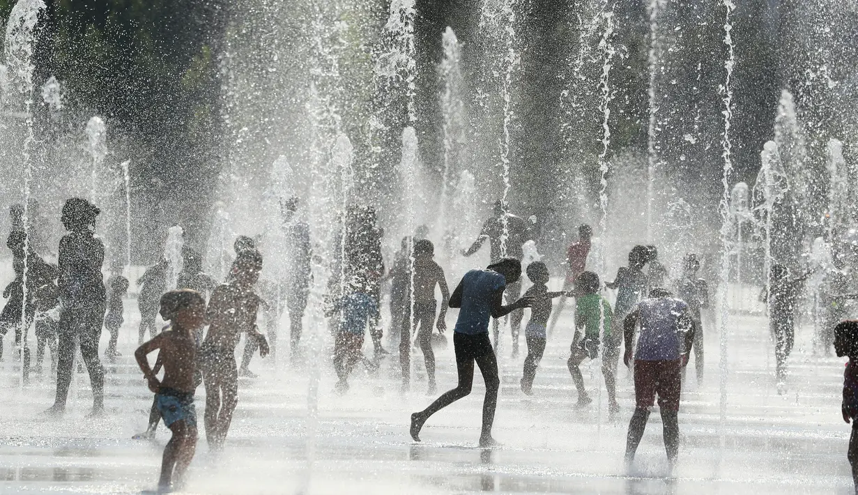 Orang-orang mendinginkan badan di air mancur saat gelombang panas menyapu seluruh Eropa utara di Nice, Prancis, Selasa (31/7). Sebagian wilayah Prancis telah menjadi daerah waspada tinggi karena meningkatnya gelombang panas. (AFP/VALERY HACHE)