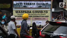 Warga melihat tanda peringatan bahaya COVID-19 di sekitar Pasar Blok A Tanah Abang, Jakarta, Selasa (1/9/2020). Guna meningkatkan kewaspadaan masyarakat, muspida kecamatan Tanah Abang memajang peti mati dilengkapi data jumlah korban COVID-19 di wilayah tersebut. (Liputan6.comHelmi Fithriansyah)