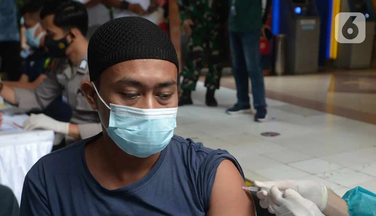 Pedagang disuntik vaksin virus corona COVID-19 di Pasar Induk Kramat Jati, Jakarta Timur, Kamis (22/7/2021). Sebanyak 250 pedagang Pasar Induk Kramat Jati menjalani vaksinasi guna menekan penyebaran COVID-19. (merdeka.com/Imam Buhori)