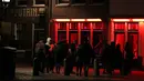 Orang-orang berjalan melewati rumah bordil di Red Light District Amsterdam, Belanda, Rabu (3/4). Pemerintah mengumumkan bakal segera mengakhiri tur wisata ke Red Light District. (REUTERS/Yves Herman)