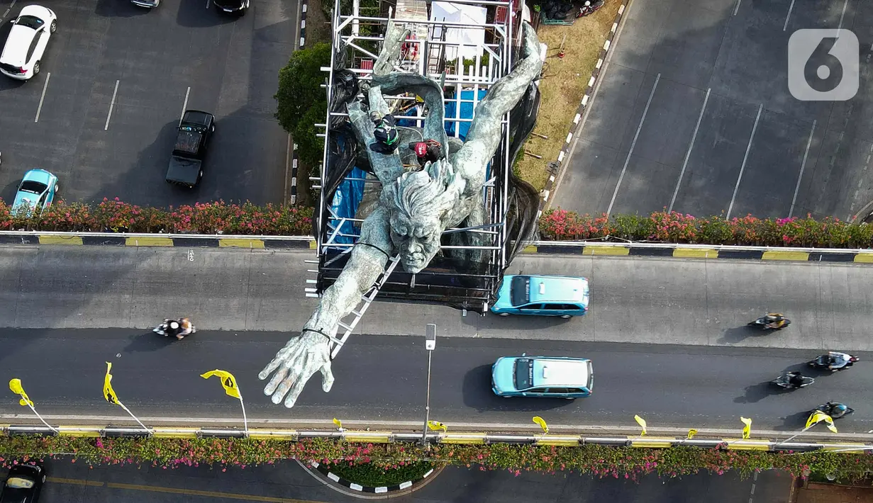 Foto udara aktivitas pekerja sedang membersihkan Patung Dirgantara di Jakarta, Selasa (17/10/2023). Kegiatan konservasi Patung Dirgantara dilakukan untuk menanggulangi kerusakan atau korosi yang terjadi pada patung tersebut. (Liputan6.com/Herman Zakharia)