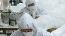 Para pekerja menjahit bahan untuk digunakan membuat pakaian antivirus di pabrik garmen Zhejiang Ugly Duck Industry, di Wenzhou, 28 Februari 2020. Wabah virus corona di China membuat produsen pakaian itu mulai memproduksi baju hazmat yang banyak diburu orang untuk melindungi dirinya. (NOEL CELIS/AFP)