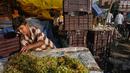Seorang pekerja muda mengatur anggur saat dia menunggu pelanggan di pasar grosir buah dan sayuran di New Delhi, India (27/3). (AFP Photo/Noemi Cassanelli)