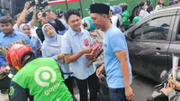 Tim Kampanye Nasional Pemilih Muda (TKN Fanta) Prabowo Subianto-Gibran Rakabuming Raka melakukan aksi bagi-bagi bunga dan cokelat kepada masyarakat di kawasan Thamrin, Jakarta Pusat, Kamis (15/2/2024). (Liputan6.com/Ady Anugrahadi)