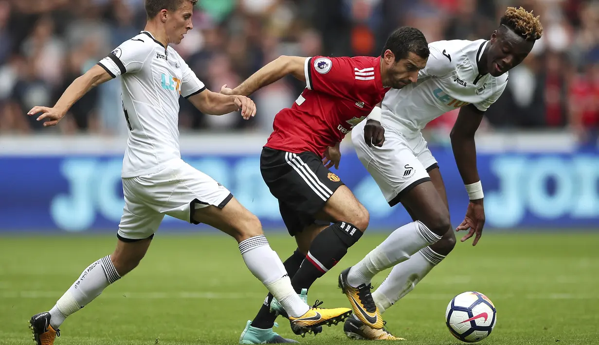 Aksi pemain Manchester United, Henrikh Mkhitaryan (tengah) melewati adangan dua pemain Swansea City pada lanjutan Premier League di Liberty Stadium, Swansea, (19/8/2017). (Nick Potts/PA via AP)
