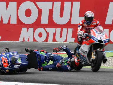 Pembalap Ducati, Andrea Dovizioso menghindari pembalap Yamaha Movistar, Maverick Vinales yang terjatuh saat balapan MotoGP Belanda di Sirkuit Assen, Minggu (25/6). Vinales gagal masuk finis karena mengalami kecelakaan di lap 12 (AP/Geert Vanden Wijngaert)