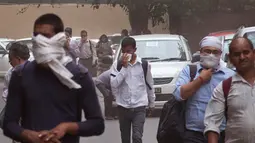 Warga beraktivitas dengan memakai penutup hidung saat badai debu menyelimuti New Delhi, India, Rabu (2/5). Badai pasir yang menerjang wilayah utara India ini telah menewaskan 77 orang. (AP Photo/Manish Swarup)
