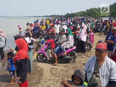 Warga berkerumun menantikan evakuasi pesawat Lion Air JT 610 di Pantai Pakis Jaya, Karawang, Jawa Barat, Senin (29/10). Warga yang penasaran berduyun-duyun datang ke pantai dekat lokasi jatuhnya pesawat. (Liputan6.com/Herman Zakharia)