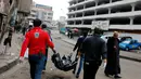 Petugas medis membawa mayat korban ledakan bom di sebuah pasar di Baghdad, Irak (31/12). Diketahui dua bom meledak, dan salah satunya diyakini sebagai bom bunuh diri. (Reuters/Ali al-Mashhadan 
