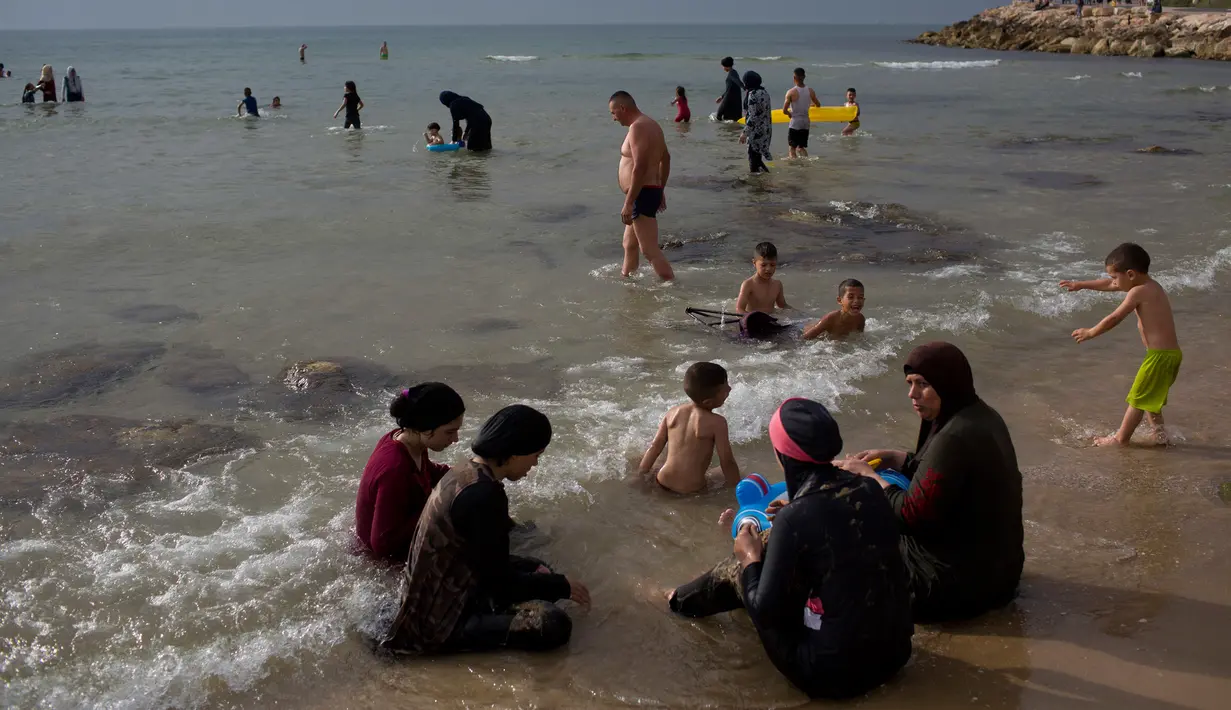 Suasana saat warga Palestina menghabiskan libur Idul Fitri di pantai Tel Aviv, Israel, Sabtu (16/6). (AP Photo/Oded Balilty)