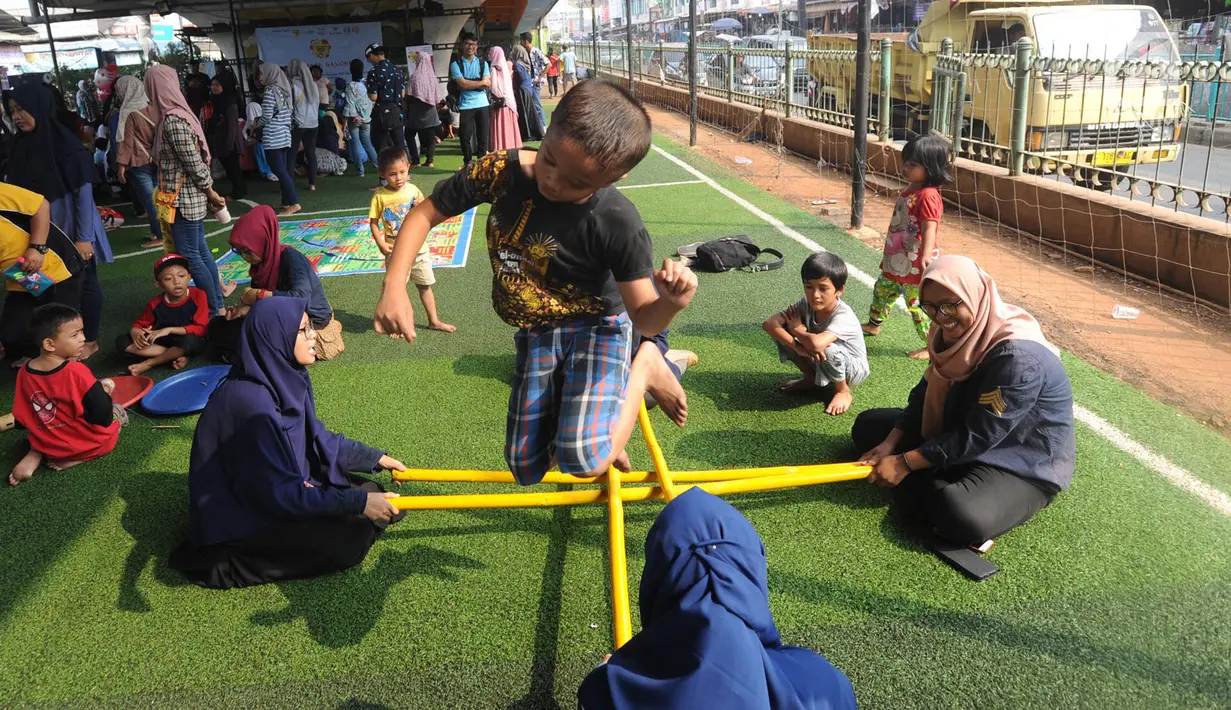 Kebahagiaan anak-anak saat bermain rangku alu di Taman Bermain Masyarakat (TBM) Kolong Ciputat, Tangsel, Banten, Minggu (22/7). (Merdeka.com/Arie Basuki)