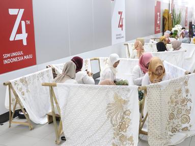 Pengrajin tengah membatik di Stasiun MRT Bundaran HI, Jakarta, Kamis (1/8/2019). Pada acara batik kemerdekaan tersebut para pengrajin membatik pada kain sepanjang 74 meter. Angka 74 disesuaikan dengan usia Republik Indonesia yang akan dirayakan 17 Agustus mendatang. (Liputan6.com/Angga Yuniar)