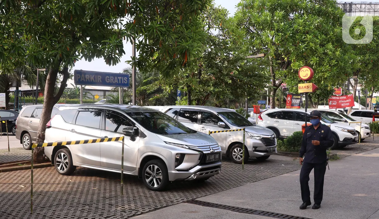 Petugas mengecek kendaraan yang parkir di Rest Area KM 13,5 Palm Square Tol Jakarta-Tangerang, Jumat (29/5/2020). Penerepan parkir berjarak dan pengecekan suhu tubuh di area tersebut diberlakukan untuk menekan penyebaran Covid-19. (Liputan6.com/Angga Yuniar)