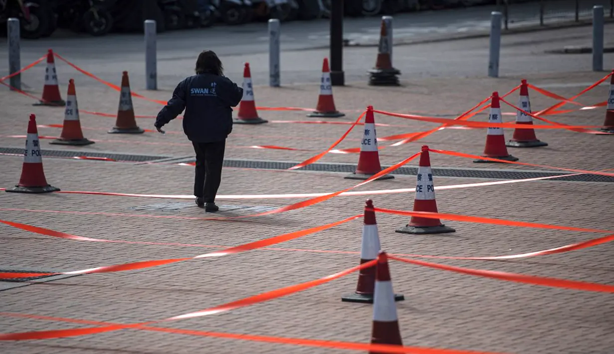Seorang wanita berjalan ke tempat pengujian virus corona COVID-19 di Hong Kong, 12 Februari 2022. Pihak berwenang bergegas untuk meningkatkan kapasitas pengujian COVID-19 menyusul rekor tertinggi infeksi baru. (Louise Delmotte/AFP)