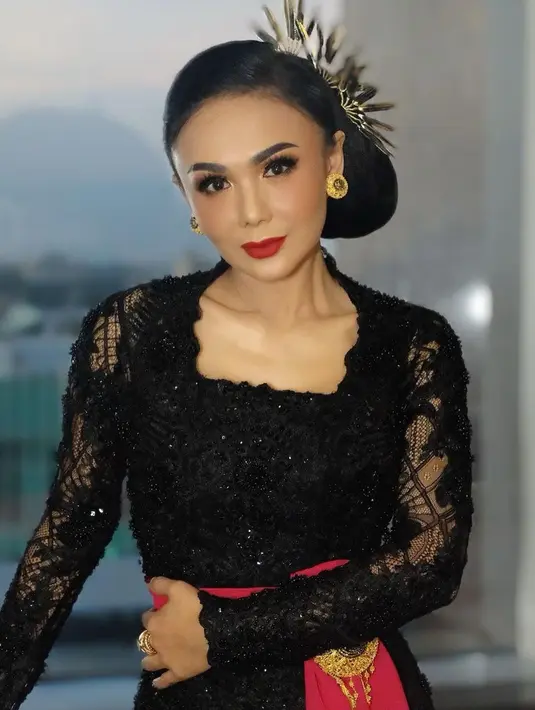 Yuni Shara tampil anggun dan memesona dengan kebaya kutu baru warna hitam dengan lengan transparan. Ia juga memakai rok jarik dan mengikat perutnya dengan kain merah. Penyanyi yang sudah  berusia setengah abad ini sukses menyita perhatian publik dengan pesonanya. (Liputan6.com/IG/@yunishara36)
