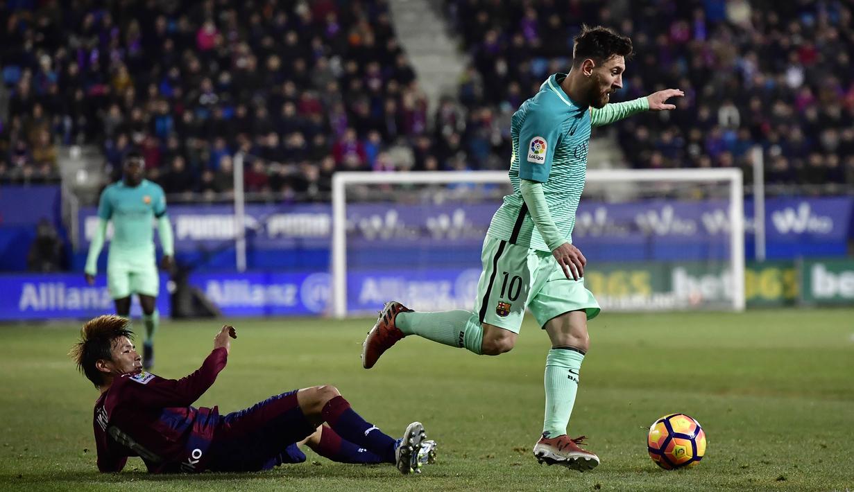 Lionel Messi berhasil mengecoh pemain Eibar, Takashi Inui pada lanjutan La Liga Spanyol di Municipal de Ipurua, Eibar, (22/1/2017). Barcelona menang 4-0.(AP/Alvaro Barrientos)