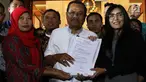 Jaksa Agung HM Prasetyo (tengah) menerima surat jaminan penangguhan eksekusi terhadap terpidana kasus pelanggaran UU ITE, Baiq Nuril Maknun(kiri)  dari anggota DPR Fraksi PDIP Rieke Diah Pitaloka di gedung Kejaksaan Agung, Jakarta, Jumat (12/7/2019). (Liputan6.com/Johan Tallo)