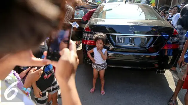 Anak kecil berfoto di belakang mobil Presiden Jokowi