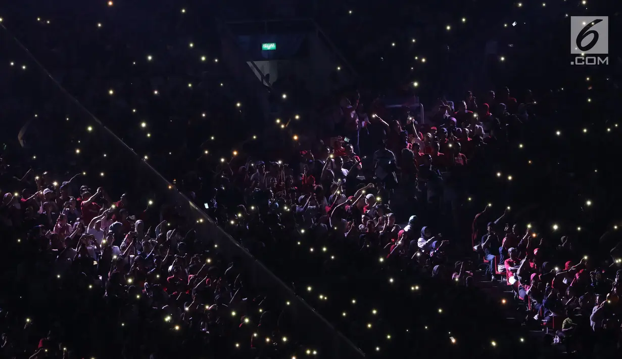 Ribuan penonton menyalakan flash ligt di ponselnya masing-masing saat malam penutupan Asian Games 2018 di Stadion GBK, Jakarta, Minggu (9/2). Hal ini menjadi unik dan menambah syahdu malam penutupan Asian Games 2018. (Liputan6.com/Helmi Fithriansyah)