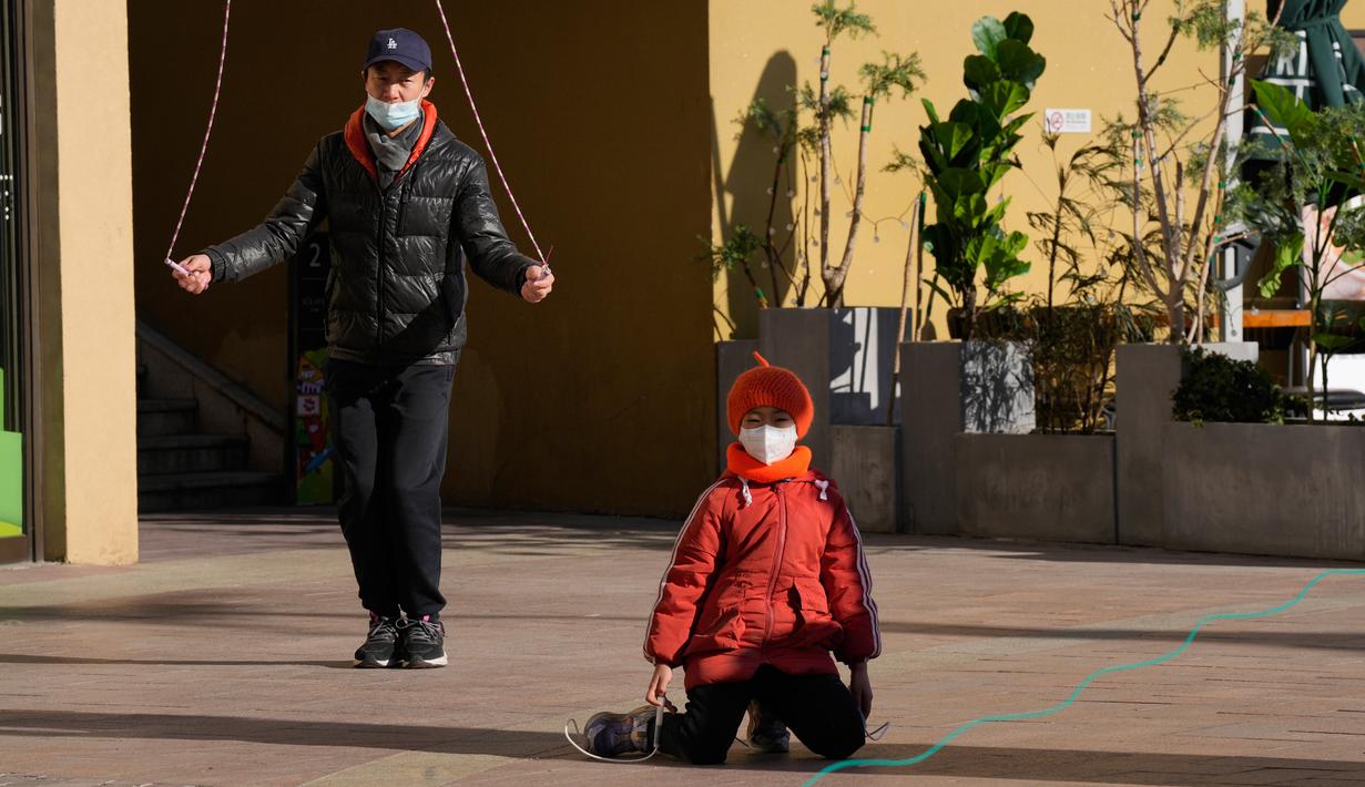 Pengunjung pusat perbelanjaan lompat tali saat menikmati cuaca sejuk di Beijing, China, 27 Desember 2022. Perusahaan menyambut baik keputusan China untuk mengakhiri karantina bagi pelancong dari luar negeri sebagai langkah penting untuk menghidupkan kembali aktivitas bisnis yang merosot, sementara Jepang mengumumkan pembatasan pengunjung saat infeksi melonjak. (AP Photo/Ng Han Guan)