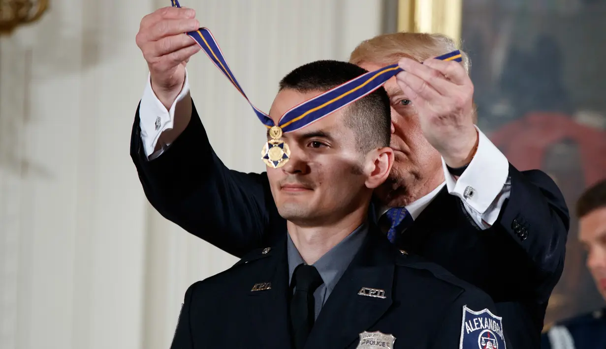 Presiden Donald Trump memberikan Medali Kehormatan kepada Alexander Jensen dari Departemen Kepolisian Alexandria, Va di Gedung Putih, Washington, (27/7). Penembakan terjadi di lapangan tempat anggota tim bisbol Partai Republik. (AP Photo/Evan Vucci)