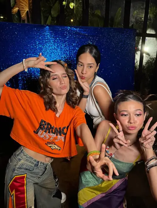 Cinta Laura hadir dengan gaya outfit y2k nya, mengenakan atasan crop orange dipadukan denim flare dengan patch. Serta aksesori gelang-gelangnya. [@claurakiehl]