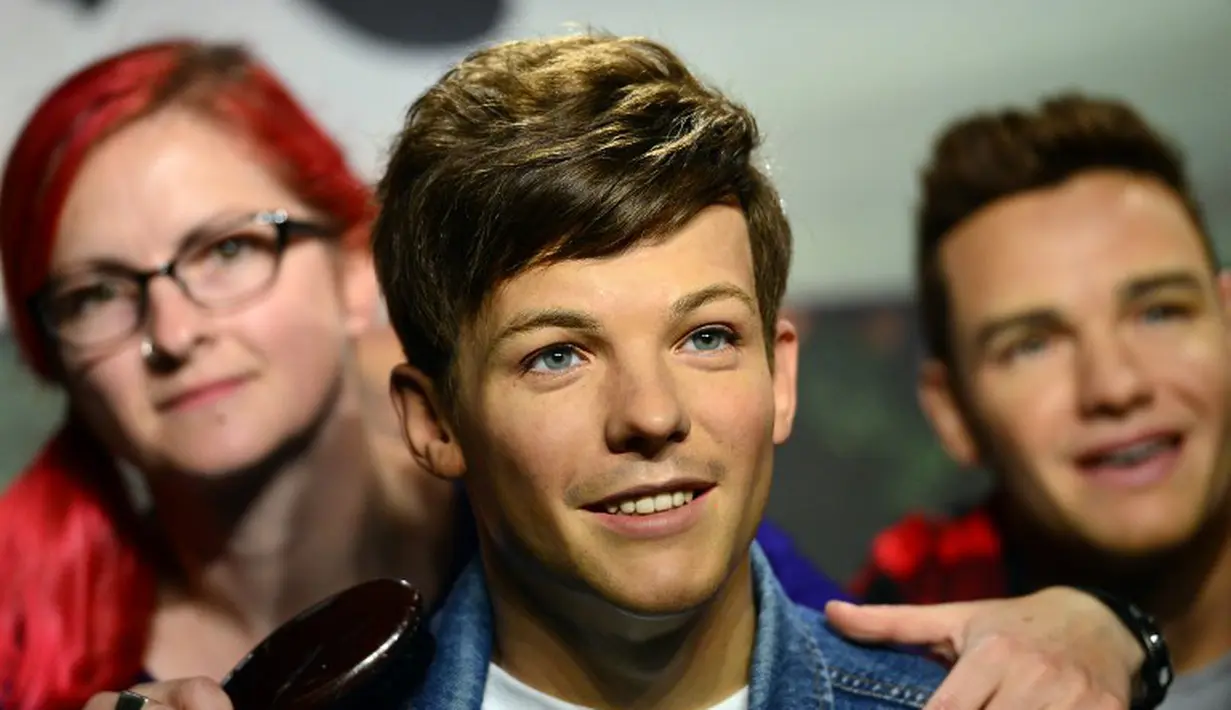 Di museum lilin Madame Tussauds di London, seorang wanita tampak berpose bersama member boyband One Direction, Louis Tomlinson, Rabu (6/8/14). (AFP PHOTO/Carl COURT)
