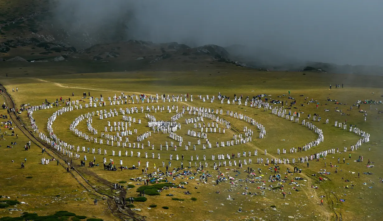 Anggota gerakan keagamaan internasional Persaudaraan Putih melakukan ritual tarian di puncak Gunung Rila, dekat Danau Babreka, Bulgaria, 19 Agustus 2021. Ribuan anggota gerakan Persaudaraan Putih berkumpul di puncak Gunung Rila untuk menyambut tahun baru spiritual mereka. (NIKOLAY DOYCHINOV/AFP)