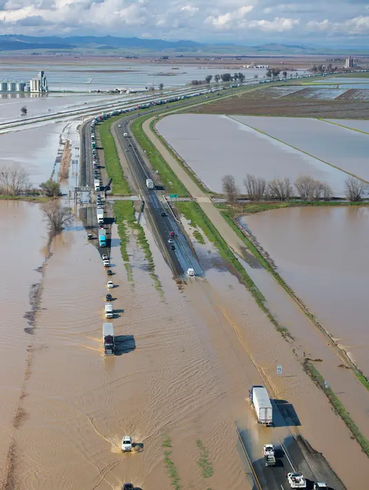 Sejumlah kendaraan melintasi banjir di Williams, California, (18/2). Badai terbesar selama enam tahun ini telah merenggut beberapa korban jiwa. (Randy Pench/The Sacramento Bee via AP)