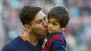 Pemain Barcelona, Lionel Messi, mencium putranya Thiago Messi jelang melawan Real Sociedad dalam lanjutan La Liga Spanyol di Stadion Camp Nou, Barcelona, (28/11/2015). (AFP Photo/Lluis Gene)