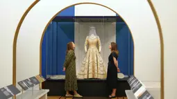 Ratusan busana mendiang Ratu Elizabeth II akan dipamerkan untuk kali pertama di Istana Buckingham, London, Inggris. Tampak dalam foto, staf Royal Collection Trust melihat busana pernikahan Putri Elizabeth, yang dipamerkan di pameran 'Queen Elizabeth II: Her Life in Style', di The King's Gallery, Istana Buckingham, London, Inggris, Kamis 9 April 2026. (AP Photo/Kirsty Wigglesworth)