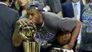 Pemain Warriors, Andre Iguodala mencium trofi usai mengalahkan Cleveland Cavaliers di pertandingan ke enam final NBA di Quicken Loans Arena,  Cleveland, (17/6/2015). Warriors unggul atas Cavaliers 4-2 dalam format best of seven. (Reuters/Bob Donnan)