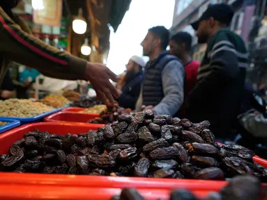 Umat Muslim Kashmir berbelanja untuk kebutuhan bulan suci Ramadan di sebuah pasar di Srinagar, Rabu 18 Februari 2026. Kurma merupakan buah favorit dan harus ada saat bulan suci Ramadan. (AP Photo/Mukhtar Khan)