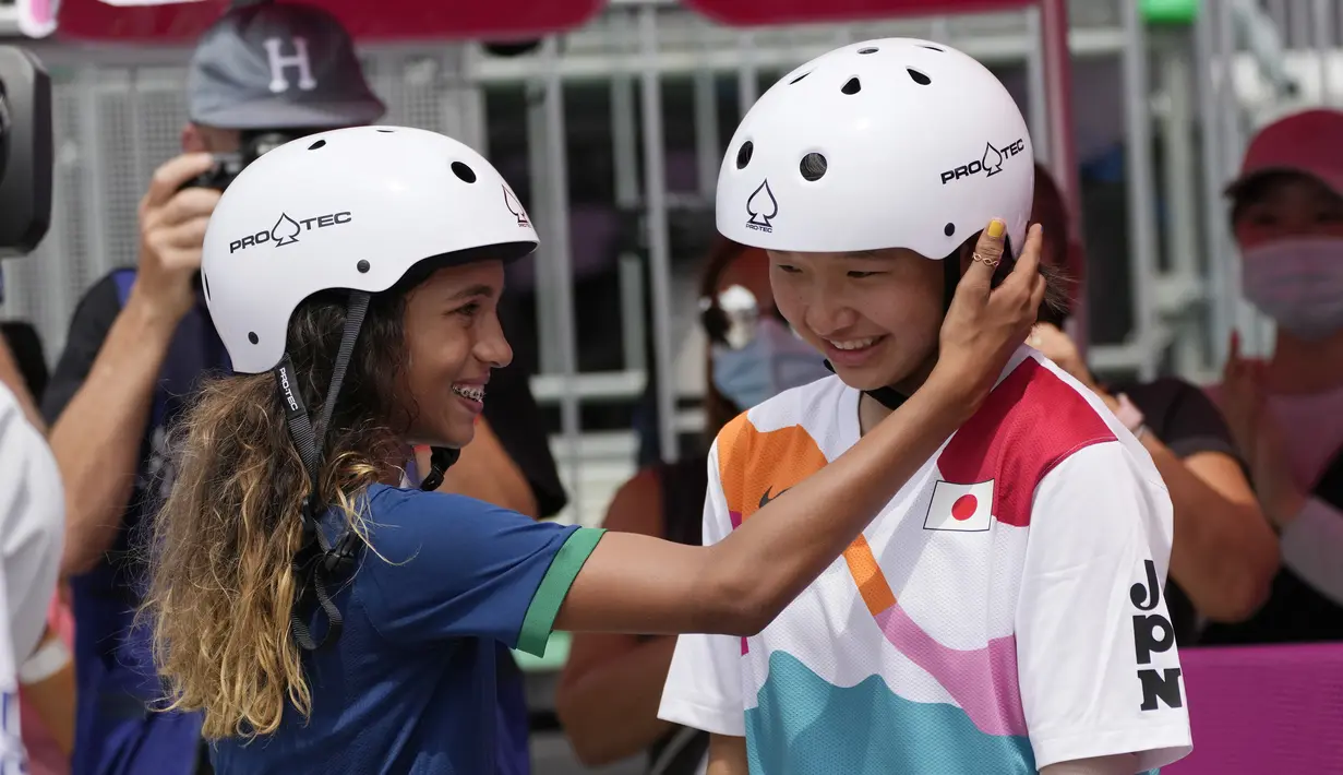 Skater Brasil Rayssa Leal (kiri) memberi selamat kepada skater Jepang Momiji Nishiya setelah memenangkan final street skateboarding putri Olimpiade Tokyo 2020 di Tokyo, Jepang, 26 Juli 2021. Momiji meraih medali emas Olimpiade saat berusia 13 tahun dan 330 hari. (AP Photo/Ben Curtis)