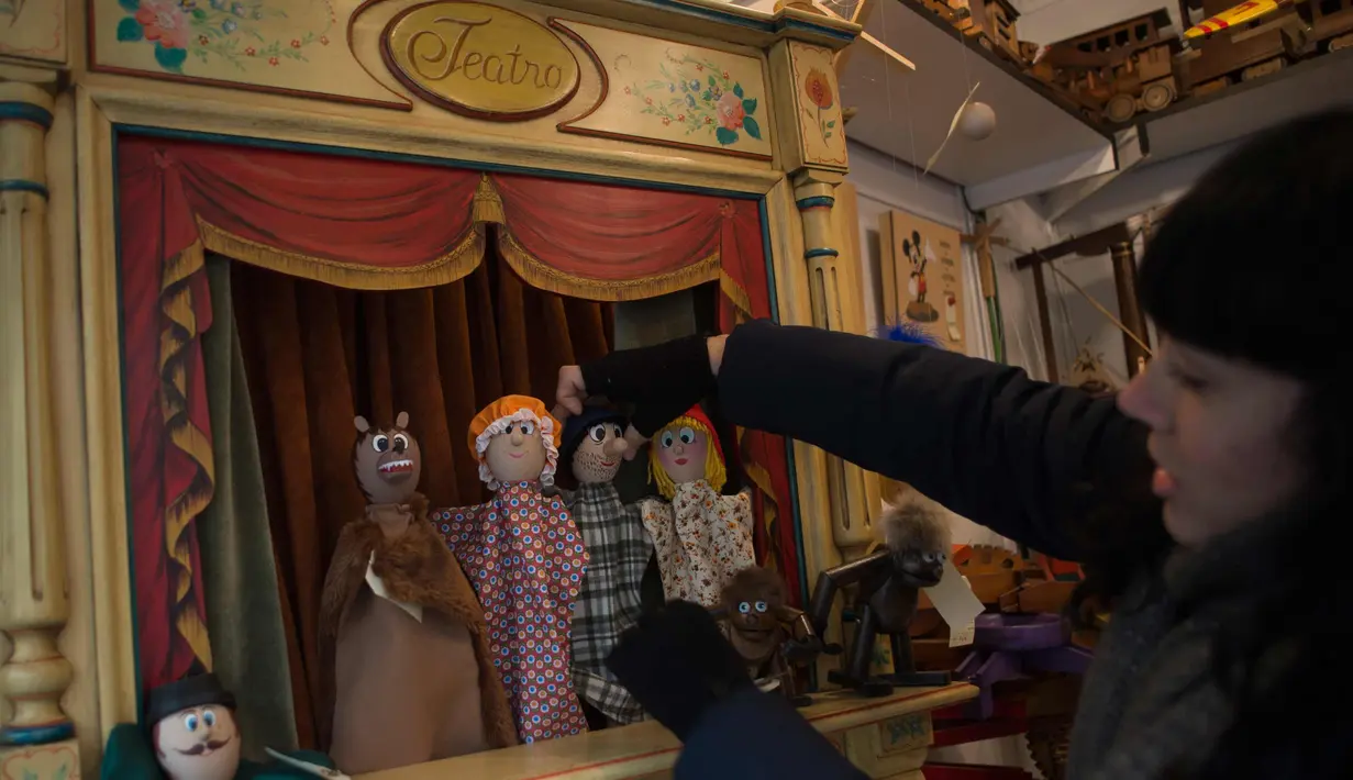 Paula Munoz (32) putri toymaker Francisco Jose Munoz merapihkan boneka kayu di bengkel "Arbole" dimana dia memproduksi mainan kayu di Albolote dekat Granada, Spanyol (11/12). (AFP Photo/Jorge Guerrero)