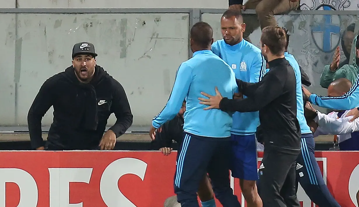 Bek Olympique Marseille, Patrice Evra berusaha ditenangkan oleh rekan-rekannya saat terlibat insiden dengan seorang suporternya menjelang partai Liga Europa lawan Vitoria Guimaraes di Estadio D. Afonso Henriques, Jumat (3/11). (AP/Luis Vieira)