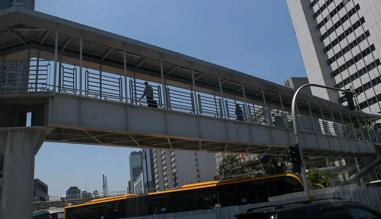 Para pejalan kaki menggunakan Jembatan Penyeberangan Orang (JPO) baru di Bundaran HI, (24/9/14). (Liputan6.com/Faizal Fanani)